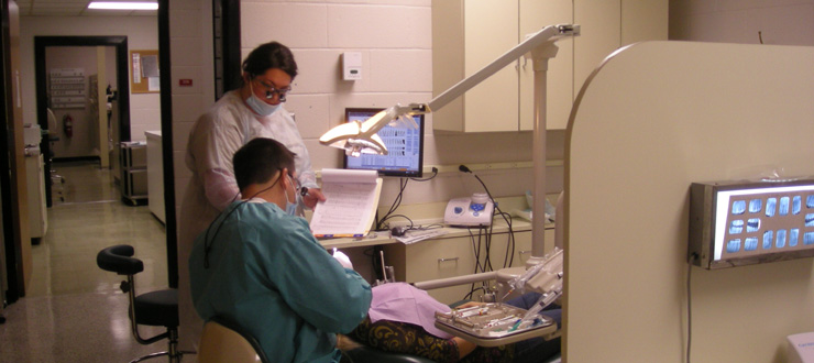 #caption4 Dental Hygiene student works with supervising faculty dentist in clinic