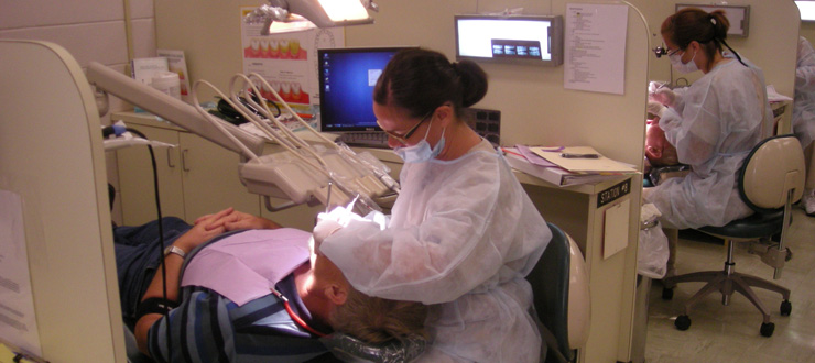 #caption5 Dental Hygiene student practices with patient in clinic
