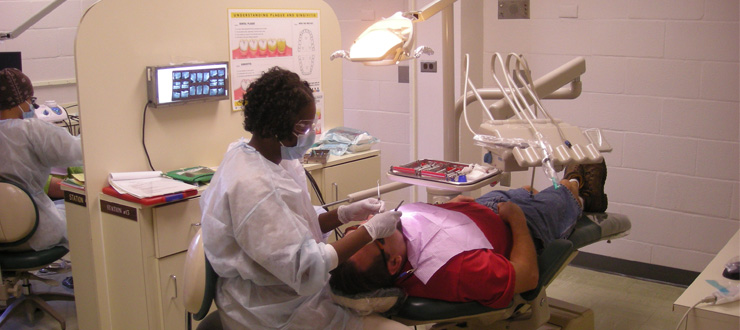 #caption6 Dental Hygiene student practices with patient in clinic