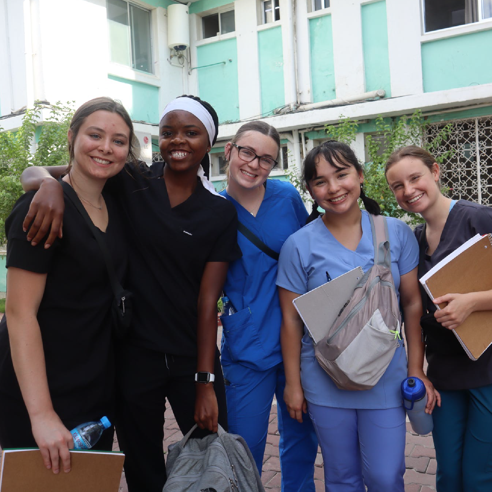 A group of students stand together and smile.