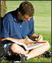 man studying in park with laptop