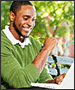 man on park bench with laptop