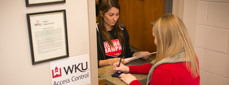 #caption7 Student picking up keys at WKU Access Control service window