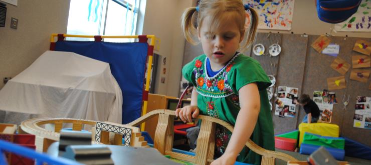 #caption6 child playing with the train table