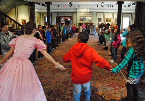 costumed docent and students dancing the virginia reel