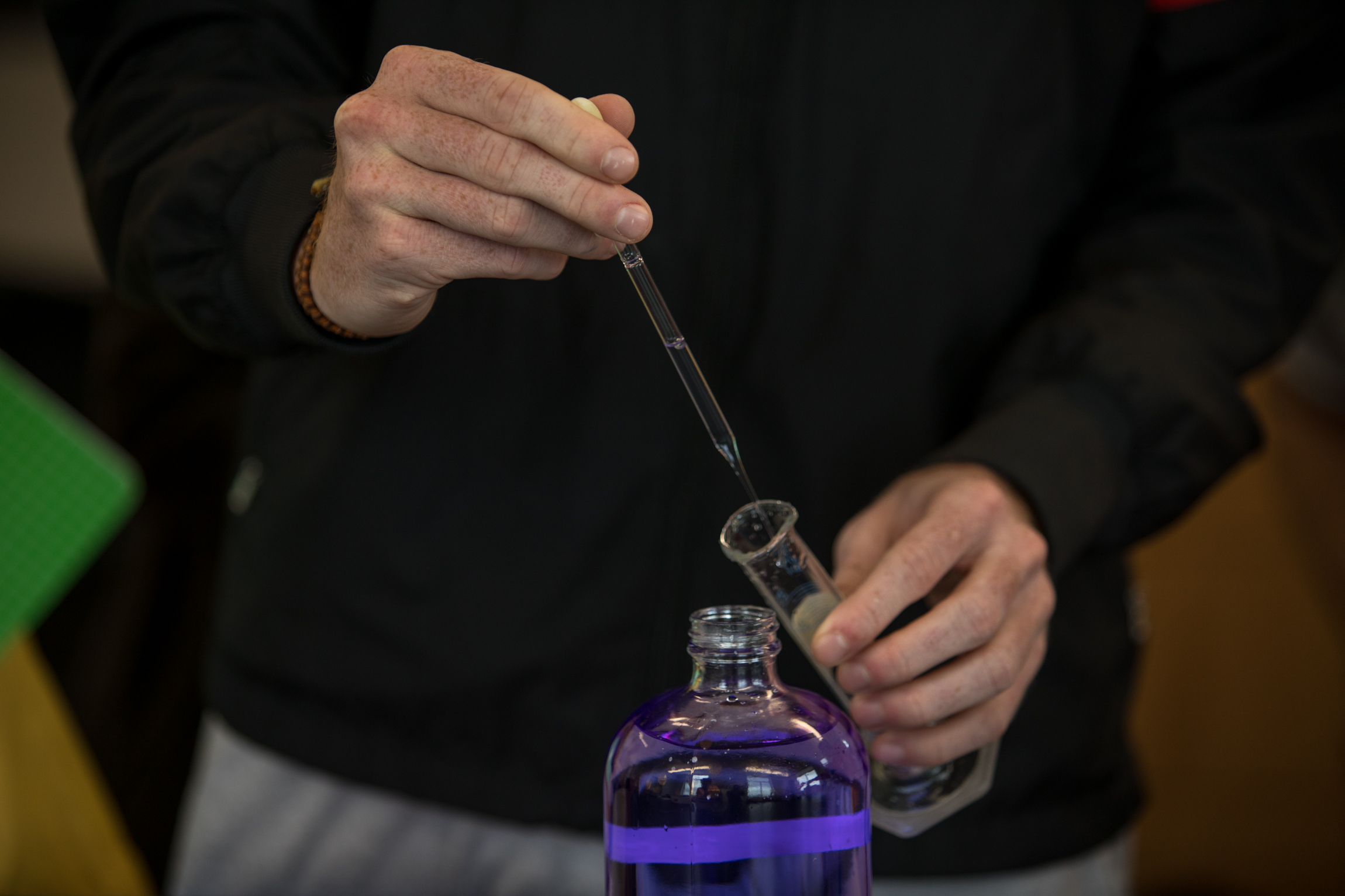 A WKU student uses a dropper to get liquid from a bottle in a chemistry lab.