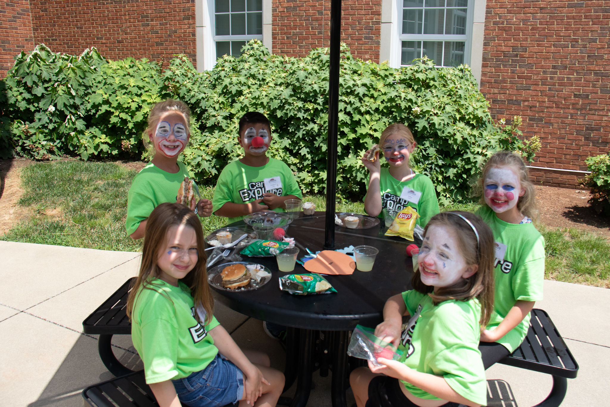 students sitting at lunch table smiling at camera