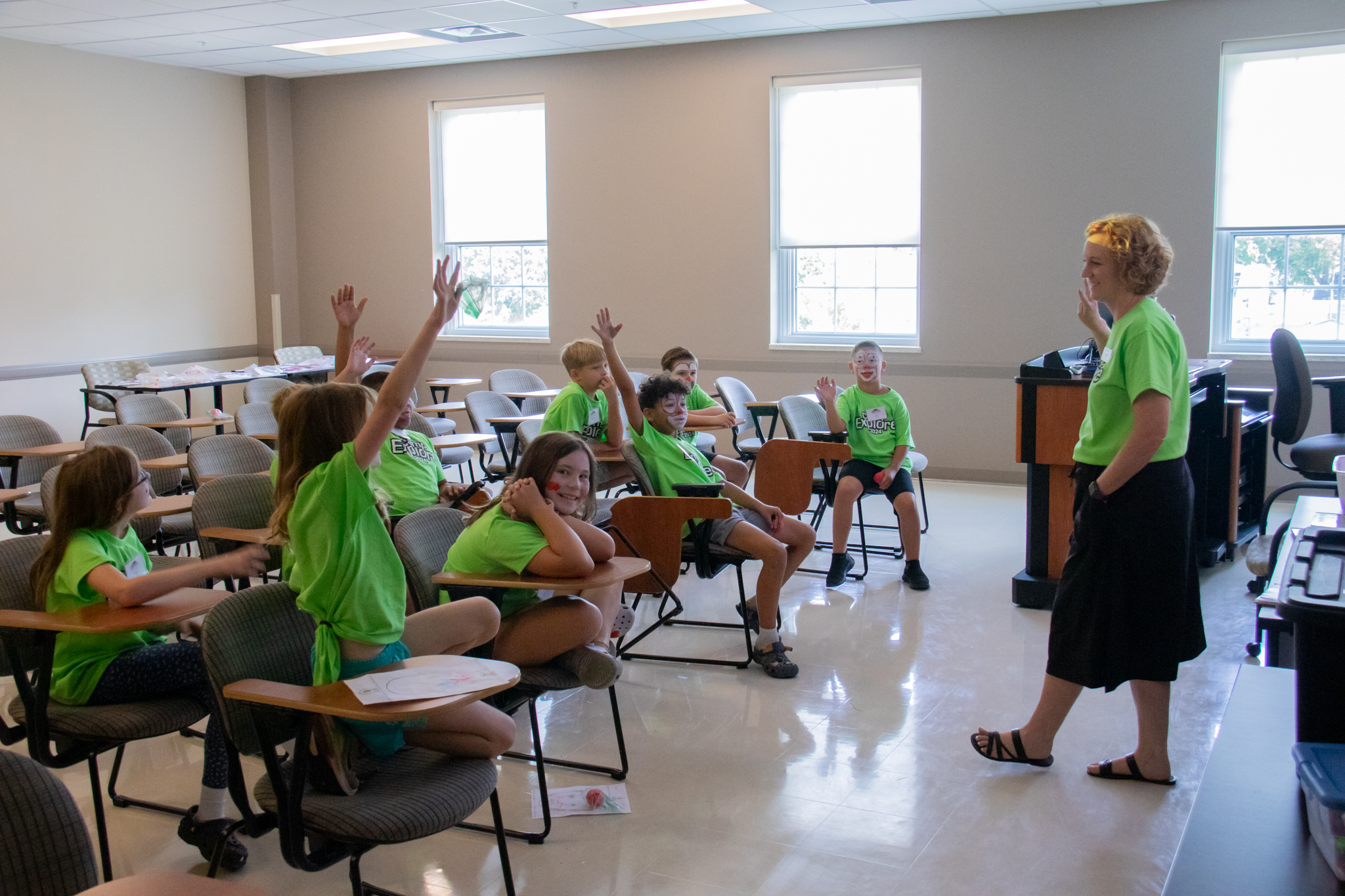 students raising hands in class