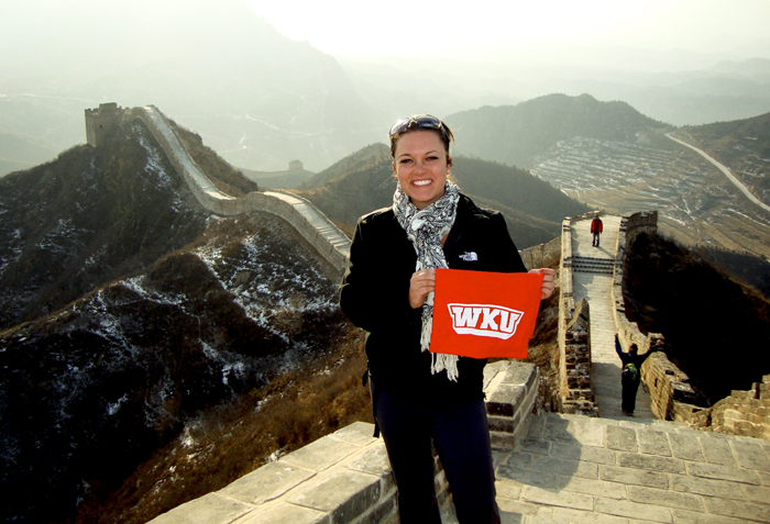 An Honors student displays her red towel on the Great Wall of China.