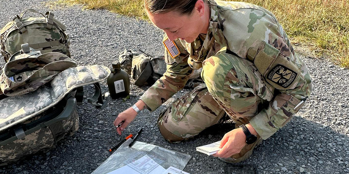 WKU ROTC LLC student working on documents on the ground 