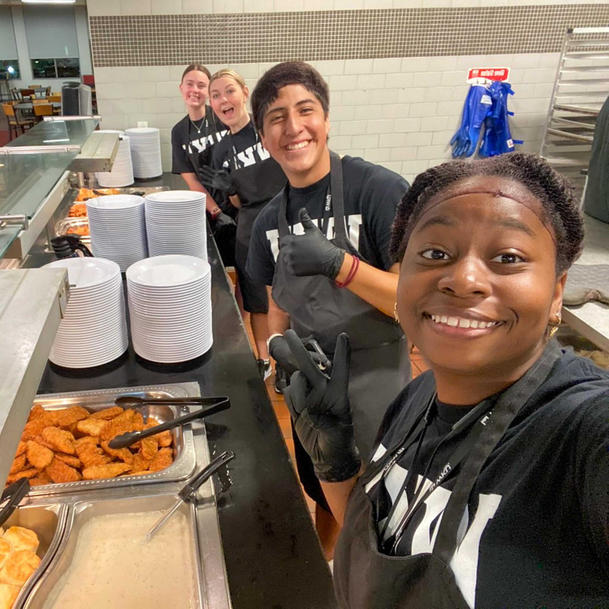 MASTER Plan Mentors smiling for a selfie while serving breakfast