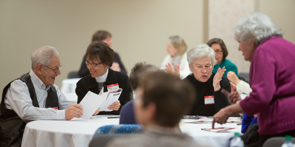 Four members of Society of Lifelong Learning at WKU talk with each other at an event. 