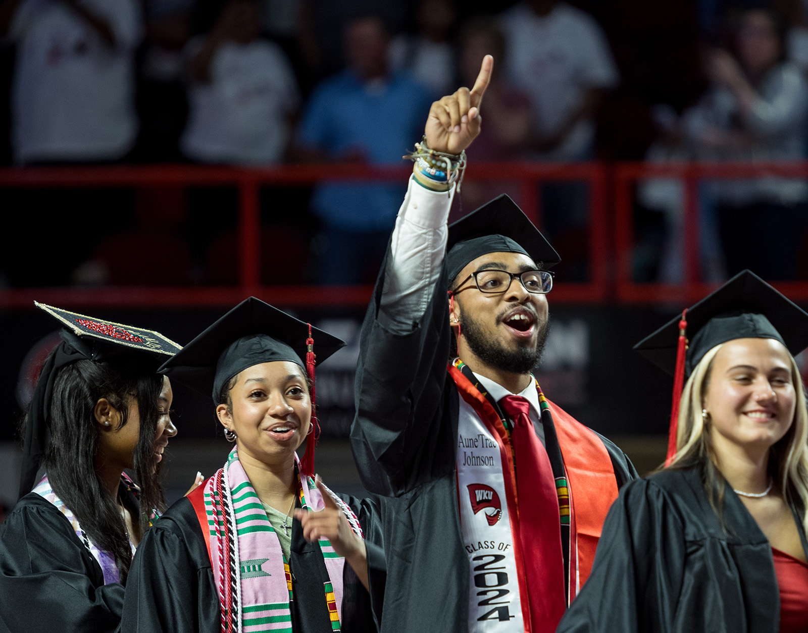 A student graduating during fall commencement with a degree in hand.