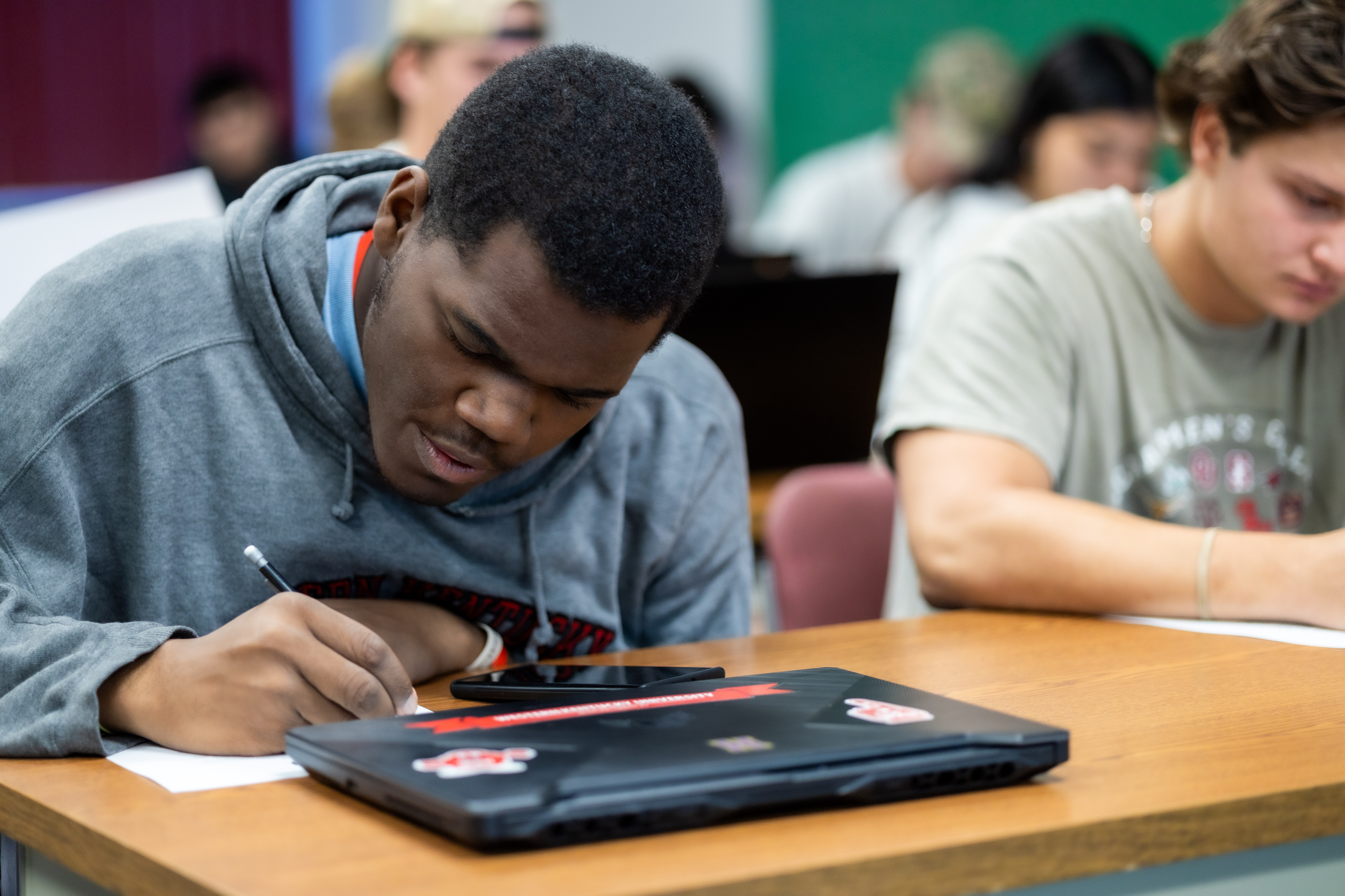 A WKU student sits in class and takes notes.