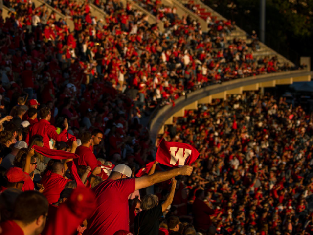Students wave red towels in WKU football stadium.