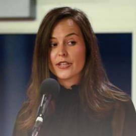 Kat Smith gives a speech into a microphone.