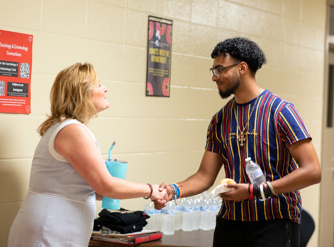 Sociology student shaking hands with professor