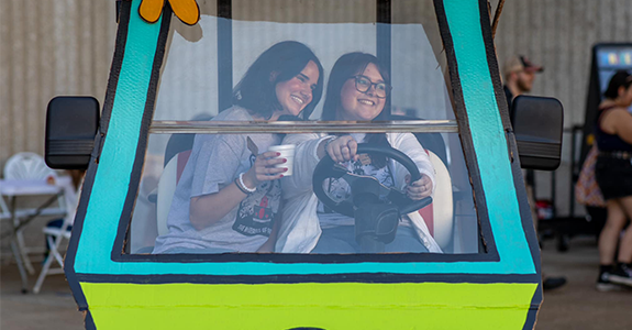 Students smiling inside the Scooby Doo Mystery Machine van at the PCAL Fall Festival.